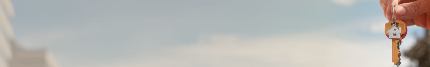 Imagem de uma mão segurando chaves de um imóvel